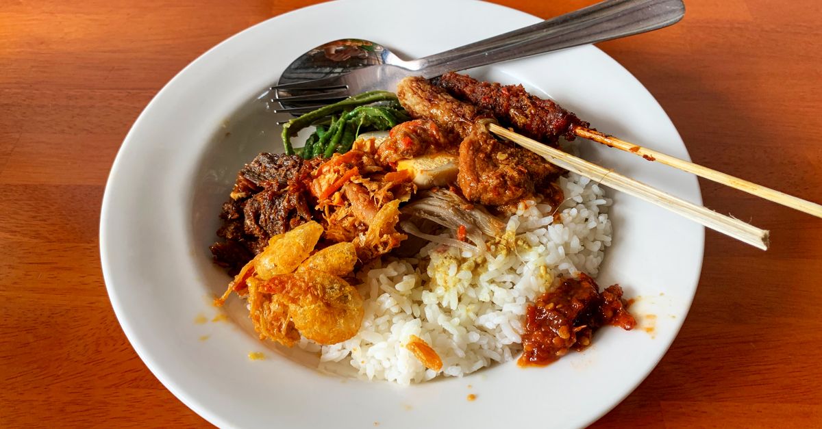 A plate of nasi campur with rice, meat and vegetables served in Bali